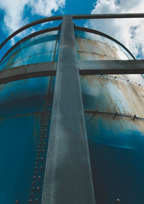 A close-up of a rusted metal fence alongside a newly coated section showing the contrast in protection.