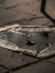 People inspecting faded outdoor painted wood and metal surfaces in bright daylight.